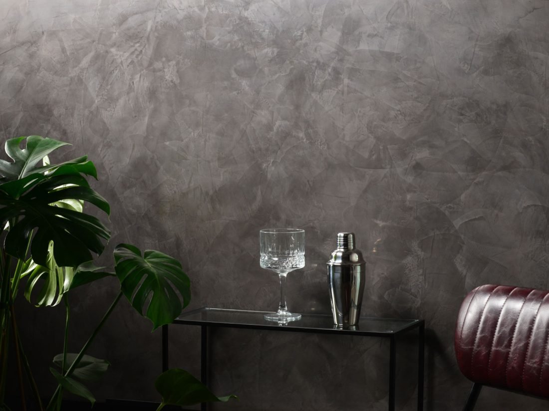 Marmorino Medium plaster finish on a wall, styled with a plant, crystal glass, and cocktail shaker